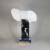 A white, roughly modelled head on a narrow dark painted support and a rectangular base.