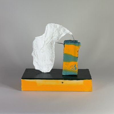 Reverse view of the white face and its exposed wire connections, with the teal and yellow support to the right.